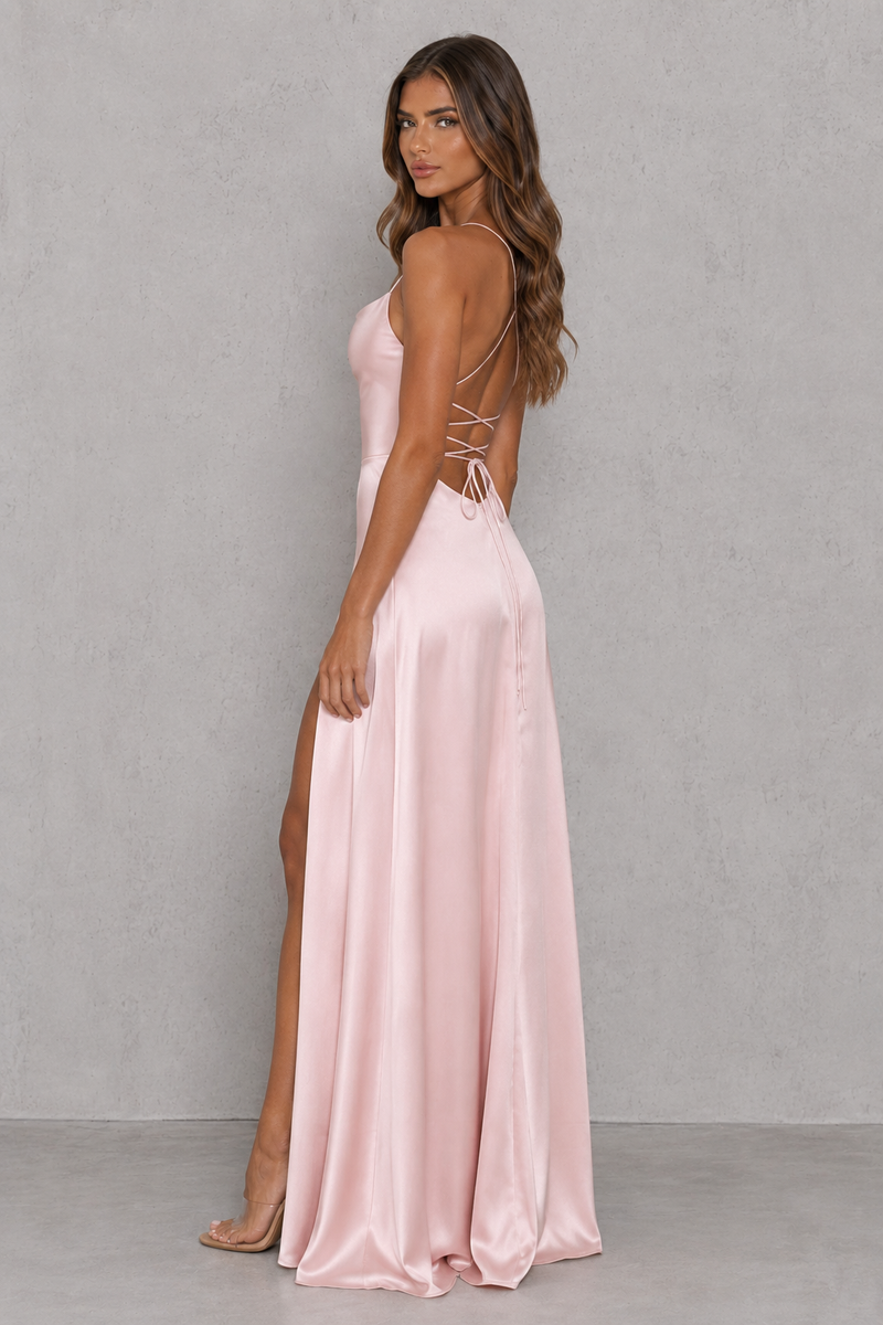 Woman wearing a pink evening gown with a backless design against a gray background
