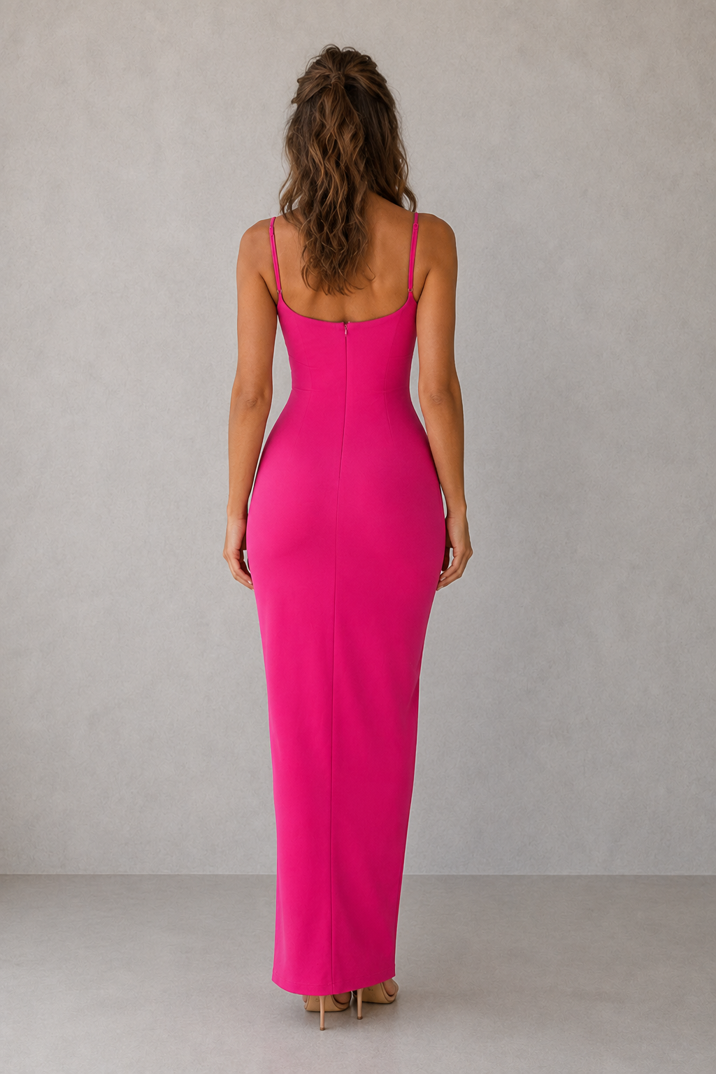 Woman wearing a bright pink dress against a plain background