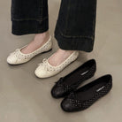 White and black flat shoes on a neutral background