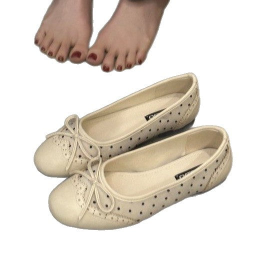 Beige ballet flats with bow detail on a white background