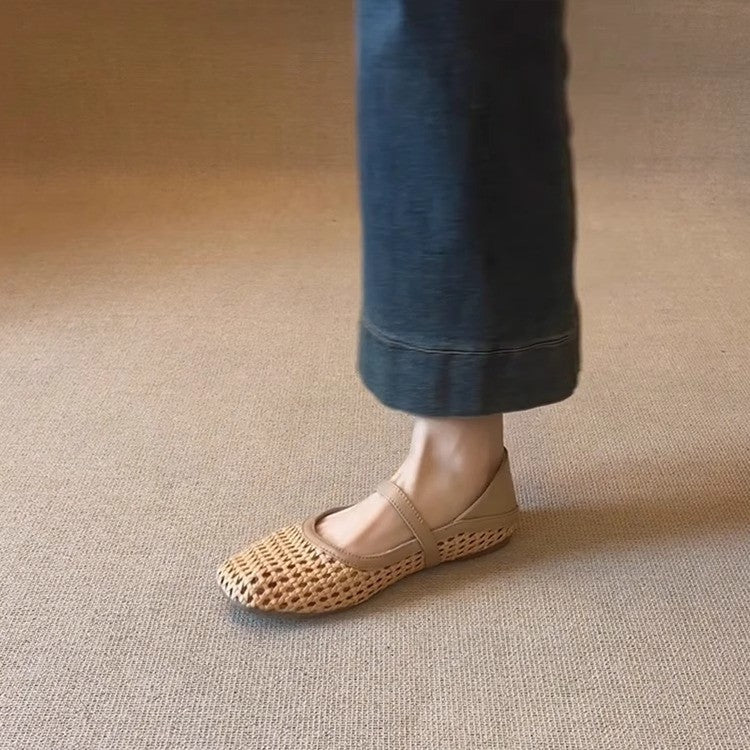 Person wearing a woven sandal on a beige carpet