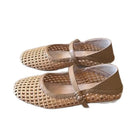 Pair of beige woven shoes with a strap on a white background