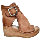 Brown wedge sandal with a buckle on a white background