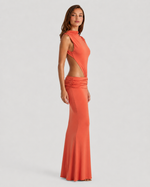Woman wearing an orange evening gown with cut-out design on a light gray background