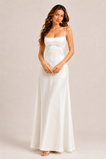 Woman wearing a white dress against a plain background