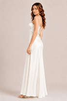 Woman wearing a white dress with lace details on a beige background