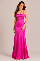 Woman wearing a pink evening gown against a beige background