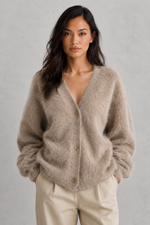 Woman wearing a beige cardigan against a gray background