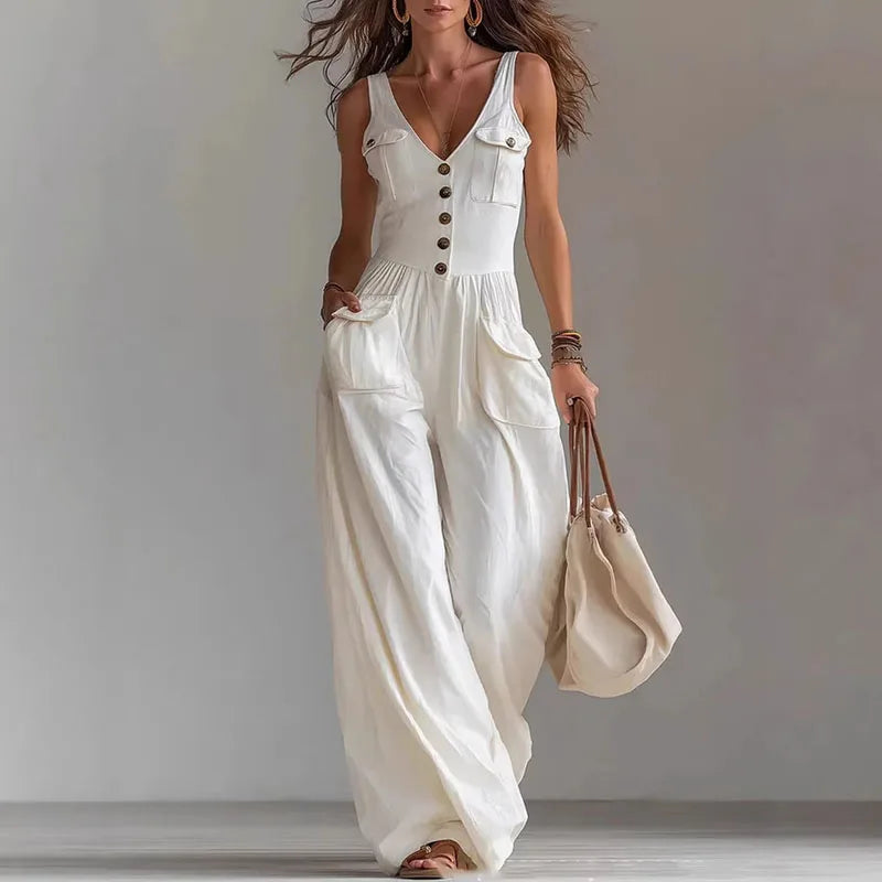Woman wearing a white sleeveless jumpsuit with a plain background