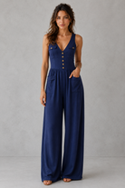 Woman wearing a blue jumpsuit against a gray background