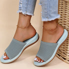 Gray sandals worn with light blue jeans on a beige background