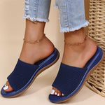 Navy blue sandals worn with light blue jeans on a beige background