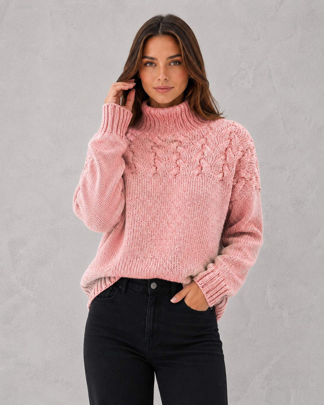 Woman wearing a pink cable knit sweater against a gray background