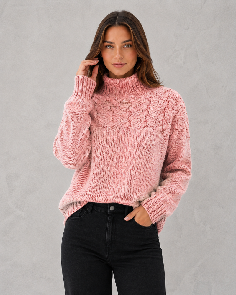 Woman wearing a pink cable knit sweater against a gray background