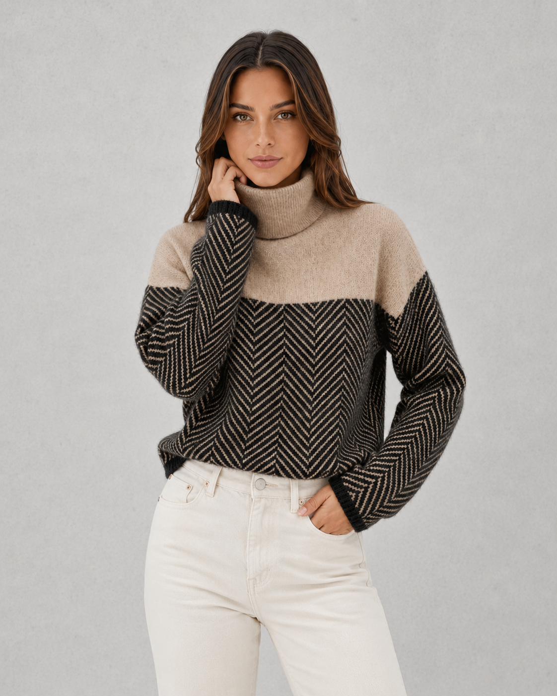 Woman wearing a two-tone sweater with a plain background