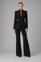 Woman wearing a black suit on a gray background