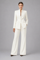 Woman wearing a white suit on a gray background