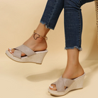 Wedges worn with rolled-up jeans on a beige background