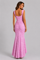 Woman wearing a pink evening gown against a gray background