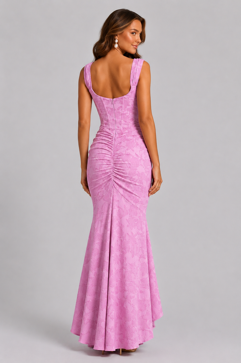 Woman wearing a pink evening gown against a gray background