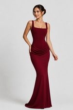 Woman wearing a burgundy evening gown on a white background
