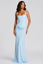 Woman wearing a light blue evening gown against a gray background