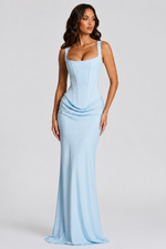 Woman wearing a light blue evening gown against a gray background
