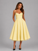 Woman wearing a yellow dress against a gray background