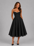 Woman wearing a black dress against a gray background