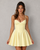 Woman wearing a yellow dress against a gray background