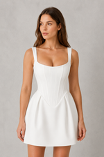 Woman wearing a white dress against a gray background