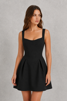 Woman wearing a black dress against a gray background