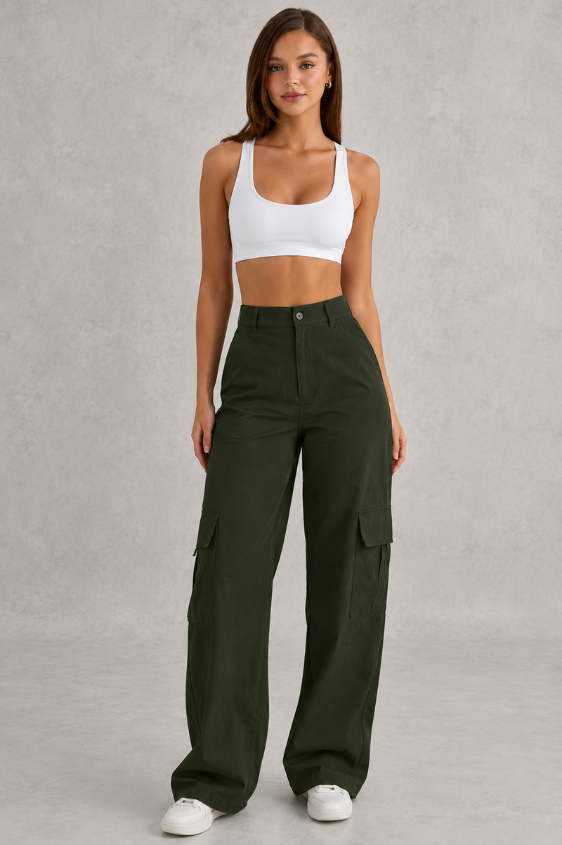 Woman wearing a white sports bra and green cargo pants on a gray background