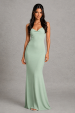 Woman wearing a mint green evening gown against a gray background
