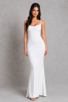 Woman wearing a white dress against a gray background