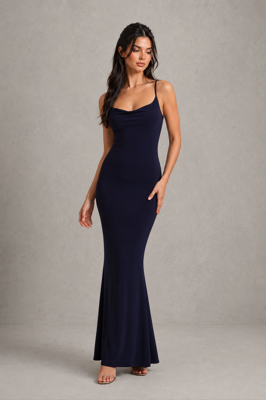 Woman wearing a navy blue dress against a gray background