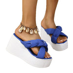 Blue sandals with white soles worn by a person on a white background