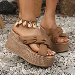 Brown platform sandals with braided design on a gravel surface