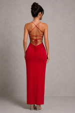 Red evening gown with thin straps and a tied back design on a plain background