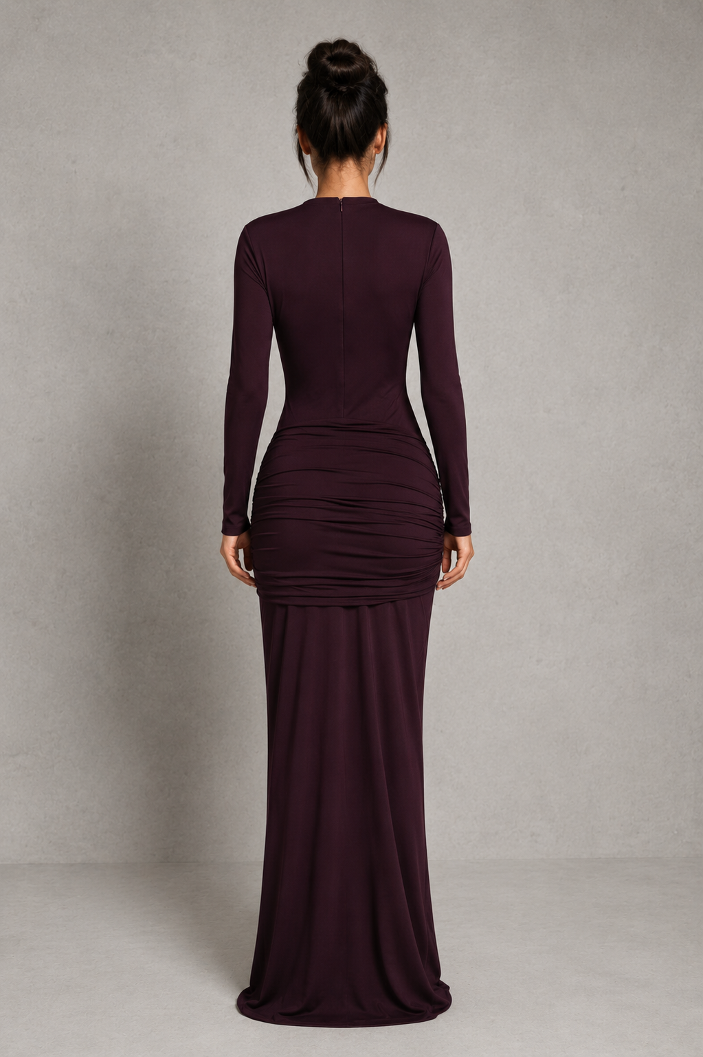 Woman wearing a long burgundy dress against a plain background