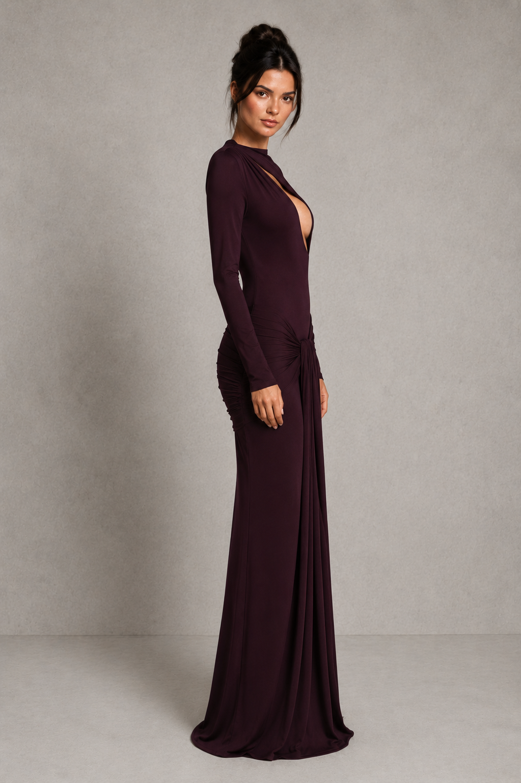Woman wearing a long burgundy dress against a plain background