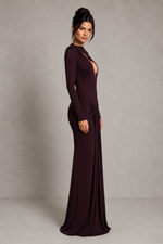 Woman wearing a long burgundy dress against a plain background