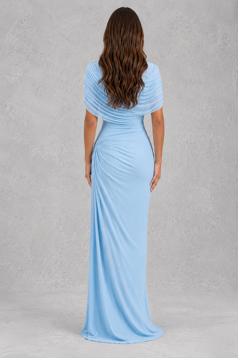 Woman wearing a light blue evening gown against a gray background