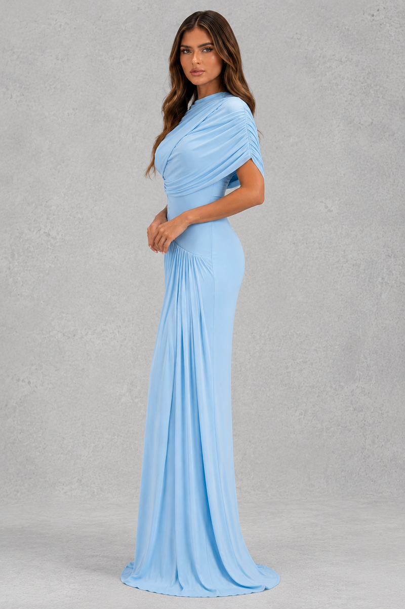 Woman wearing a light blue evening gown against a gray background