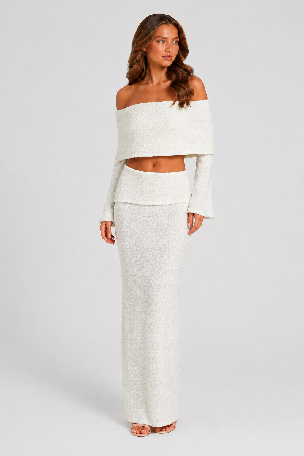 Woman wearing a white off-shoulder top and skirt set against a plain background