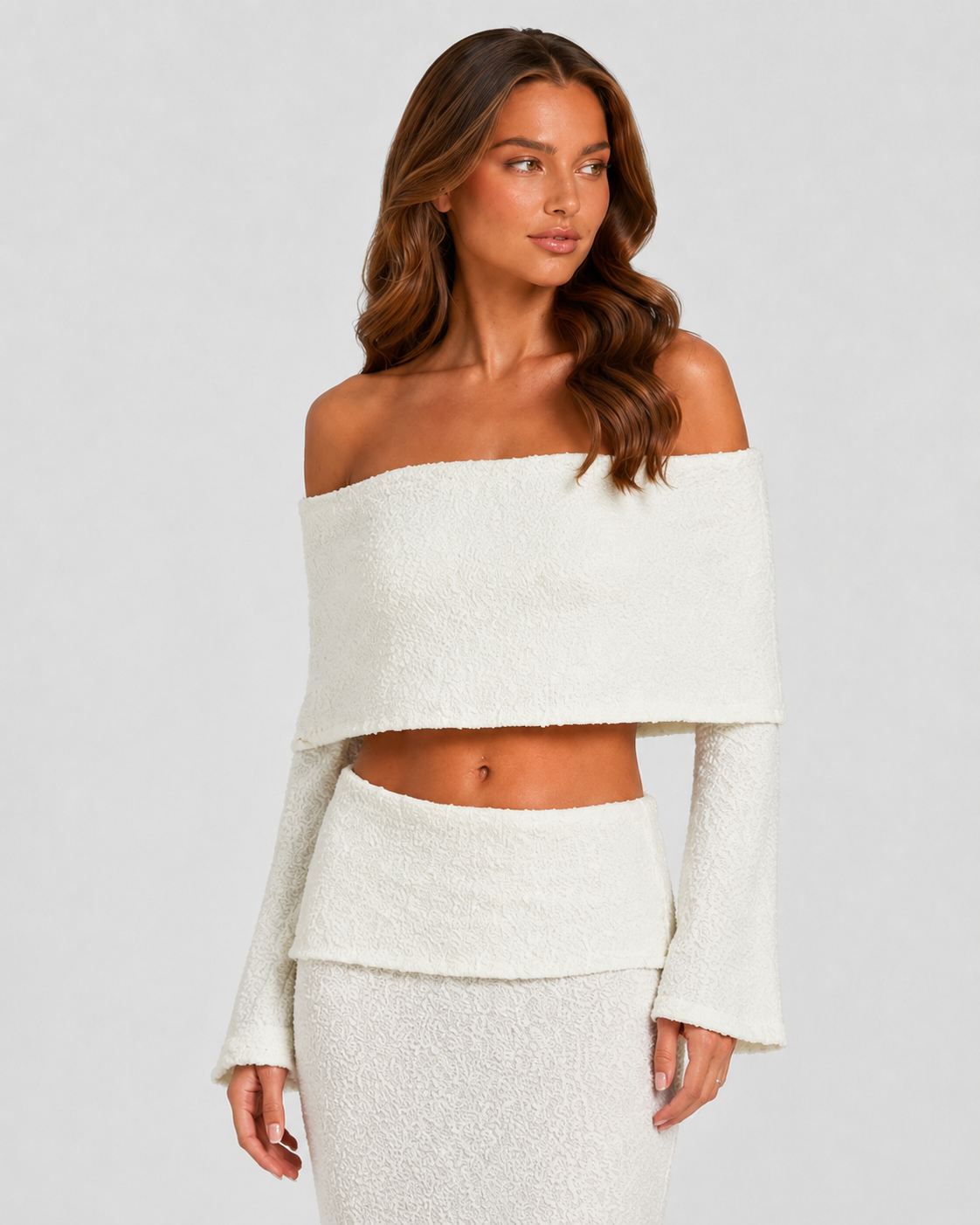 Woman wearing a white off-shoulder top and skirt set against a plain background
