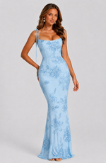 Woman wearing a light blue lace dress on a gray background