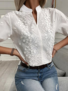 White lace blouse with short sleeves worn by a person, sitting on a couch.