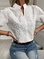 White lace blouse with short sleeves worn by a person, sitting on a couch.