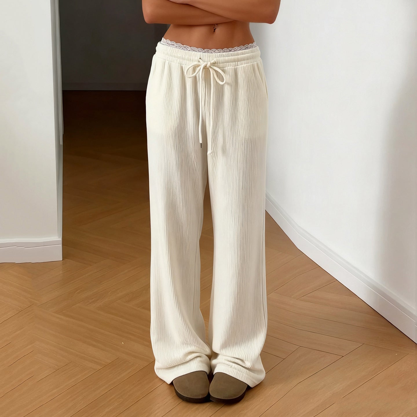 Person wearing white ribbed lounge pants standing on a wooden floor with 'APOSE' branding.